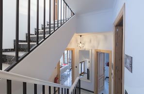 A staircase with black railings leading to a bedroom with a bed and a window. - Salamandra Plaza B&B (Còmpeta)