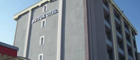 A multi-story hotel building with the sign "BUYUK OTEL" on the facade.