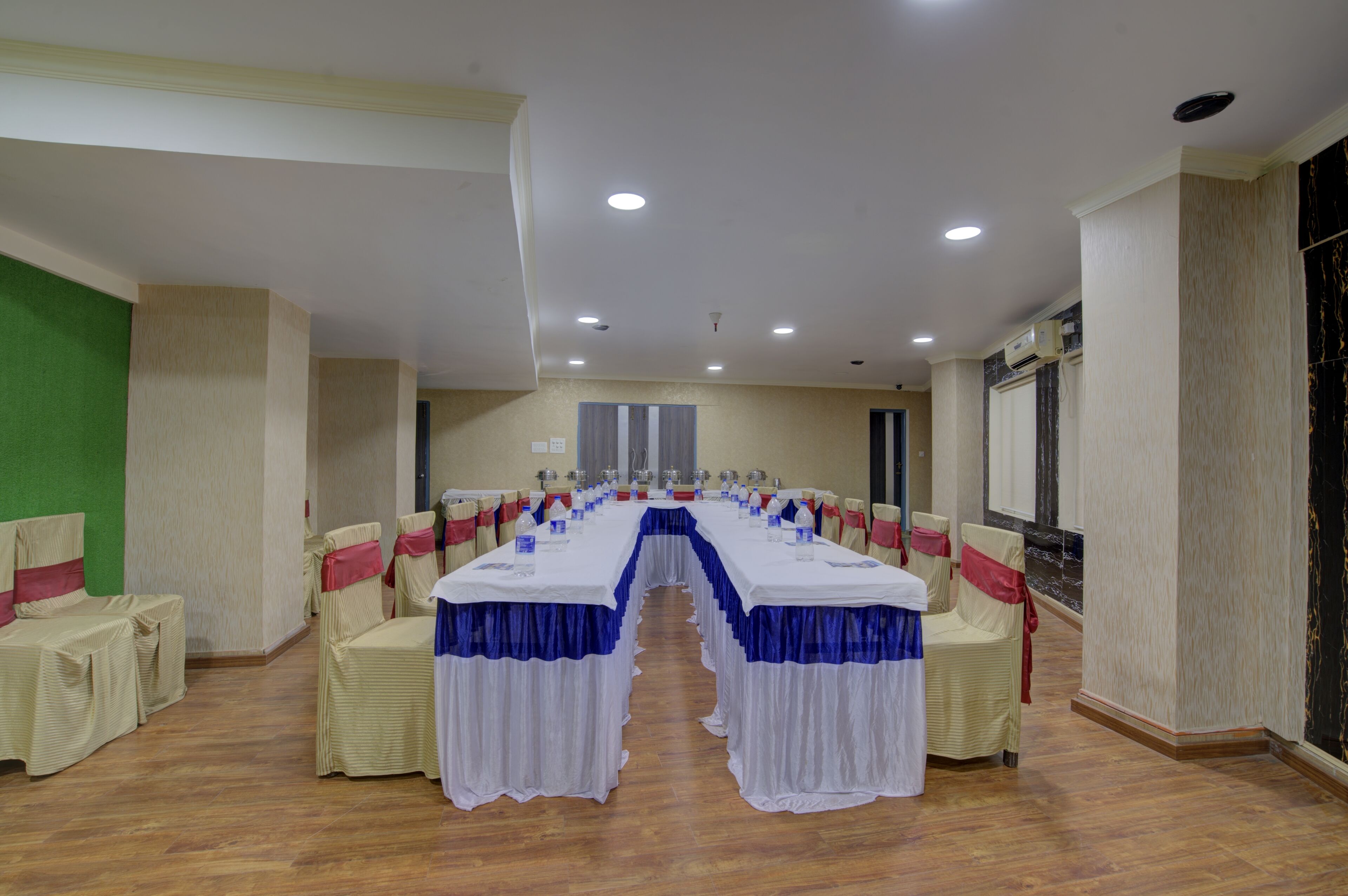 A conference room with a long table, chairs, and a green wall.
