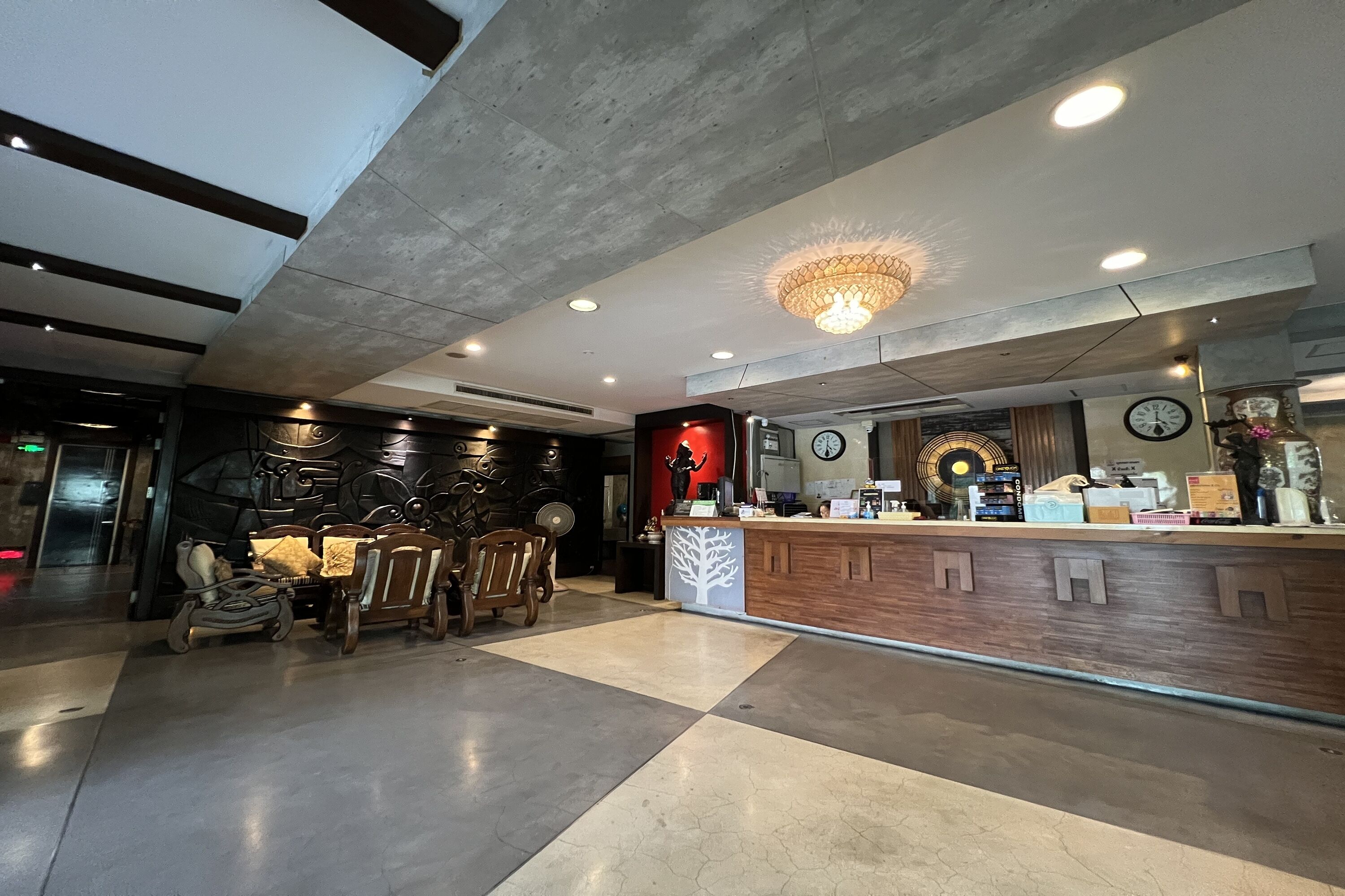 Un intérieur moderne comprenant un comptoir d’accueil, un espace détente et des œuvres d’art décoratives murales.