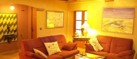 A cozy living room with two sofas, a coffee table, and a painting on the wall.
