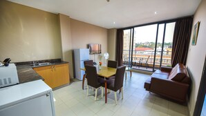 Een functionele woonruimte met kitchenette, eethoek en een bank.