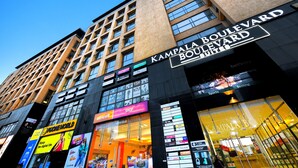 Een modern gebouw met een opvallend bord voor Kampala Boulevard Suites.