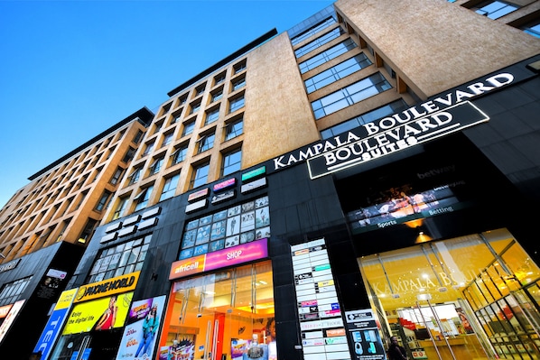 A modern building with a prominent sign for Kampala Boulevard Suites.