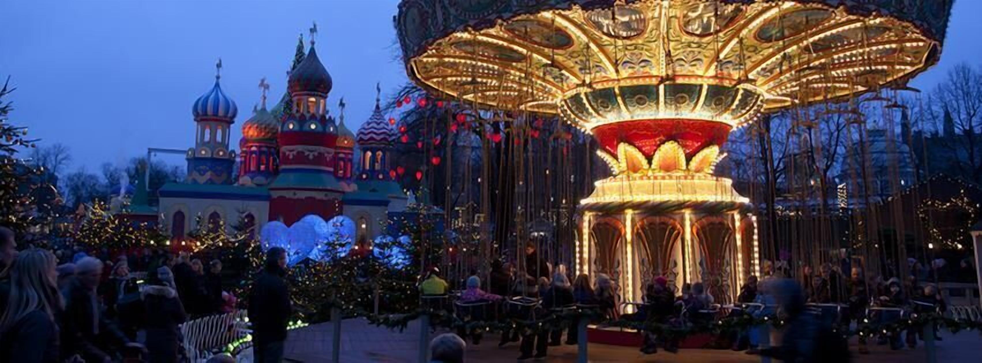 A carousel with ornate golden decorations and a crowd of people around it.