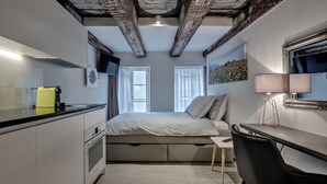A compact bedroom with a bed, bedside table, and a desk with a chair. - The Residence La Cittadella (Baden)