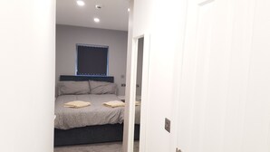 A bedroom with a bed, pillows, and a window. - Central City House (Liverpool)