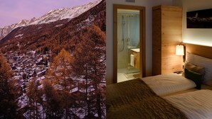 A hotel room with a wooden ceiling, a bed with pillows, a nightstand with a lamp, and a bathroom with a shower. - EVA Apartments (Zermatt)
