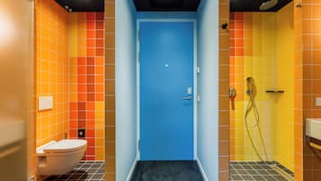 Ein Badezimmer mit blauer Tür, Toilette und Duschbereich.