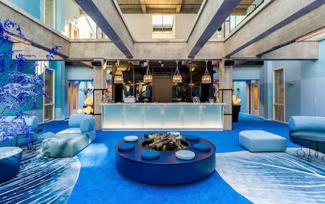 A lobby with a central seating area, a reception desk, and a high ceiling with skylights.