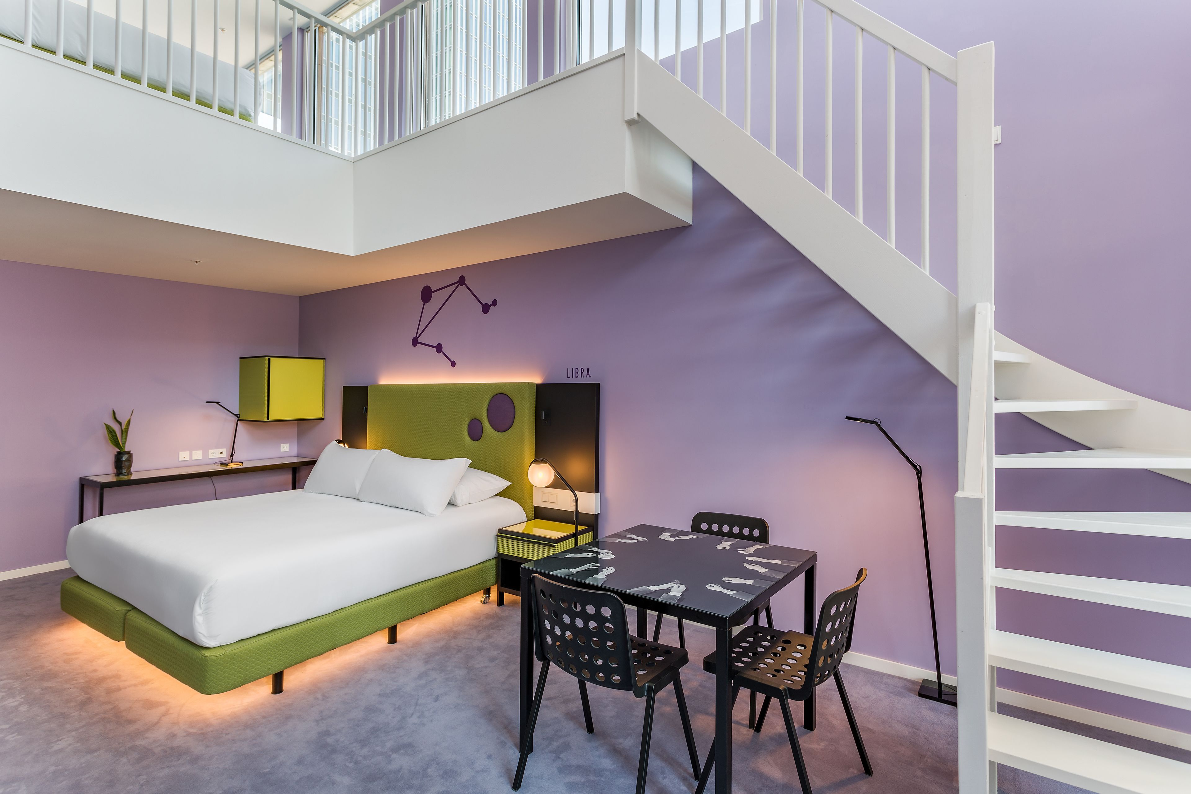 A modern bedroom with a bed, bedside tables, a desk, and a chair.