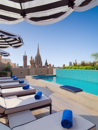 Una piscina al aire libre, sillones reclinables de piscina