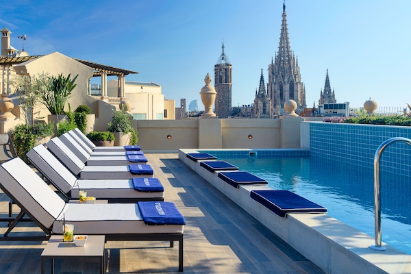 Una piscina al aire libre, sillones reclinables de piscina