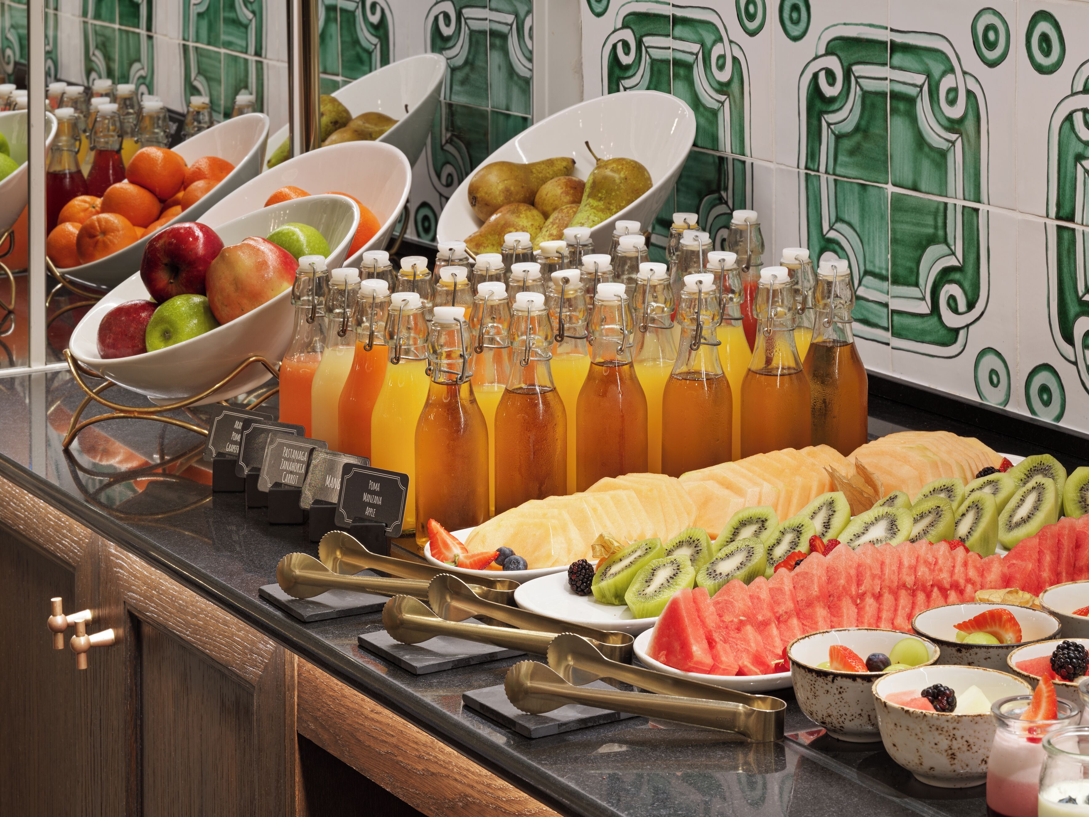 A buffet with various fruits, vegetables, and beverages.