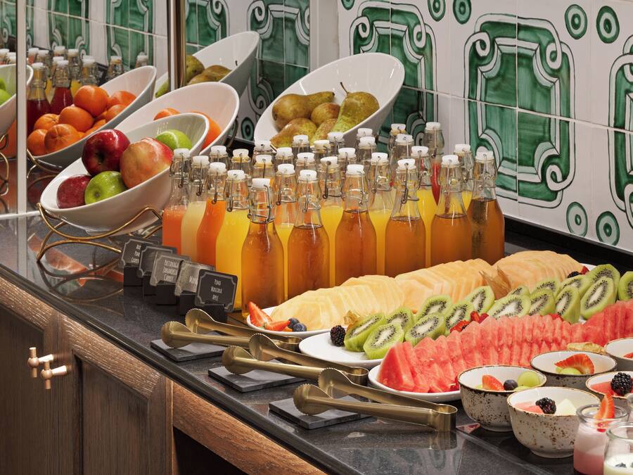 Un bufé con diversas frutas, verduras y bebidas.