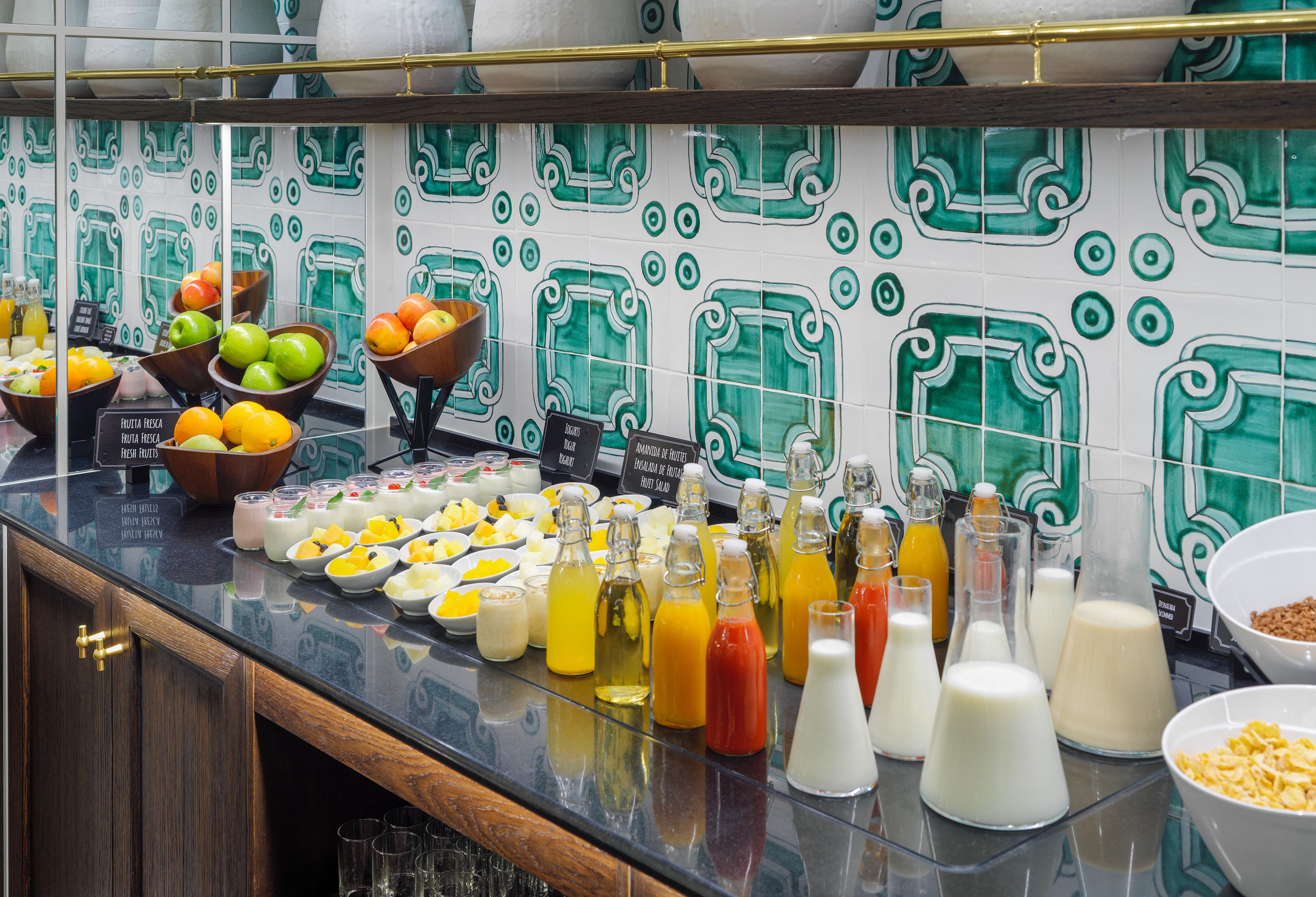 A breakfast buffet with various fruits, juices, and dairy products.