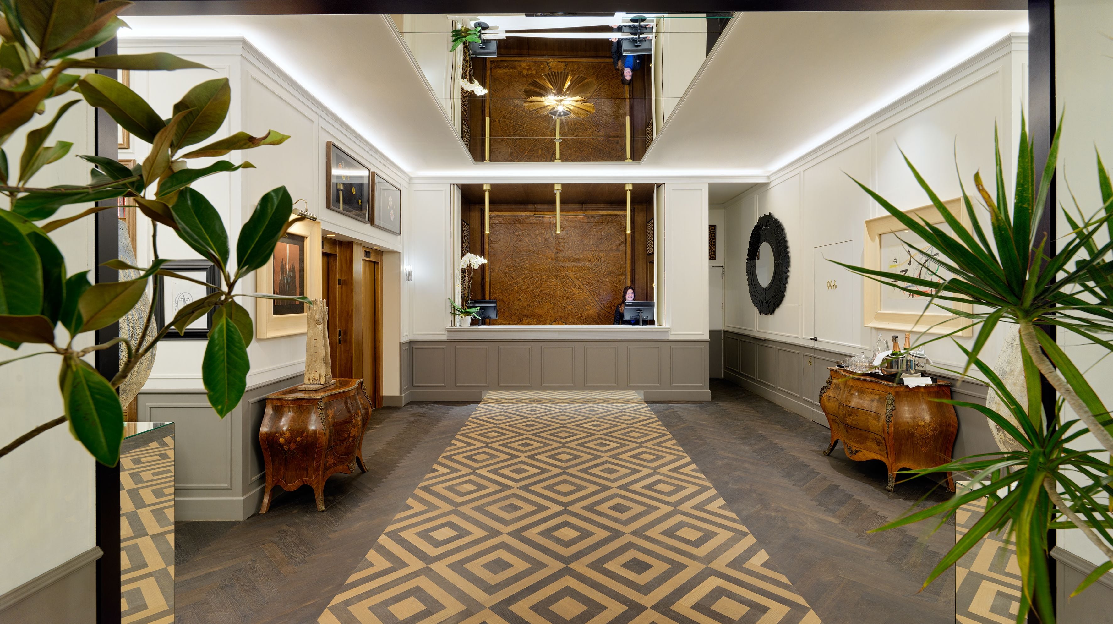 Un pasillo con alfombra estampada, muebles de madera y una mesa de recepción.