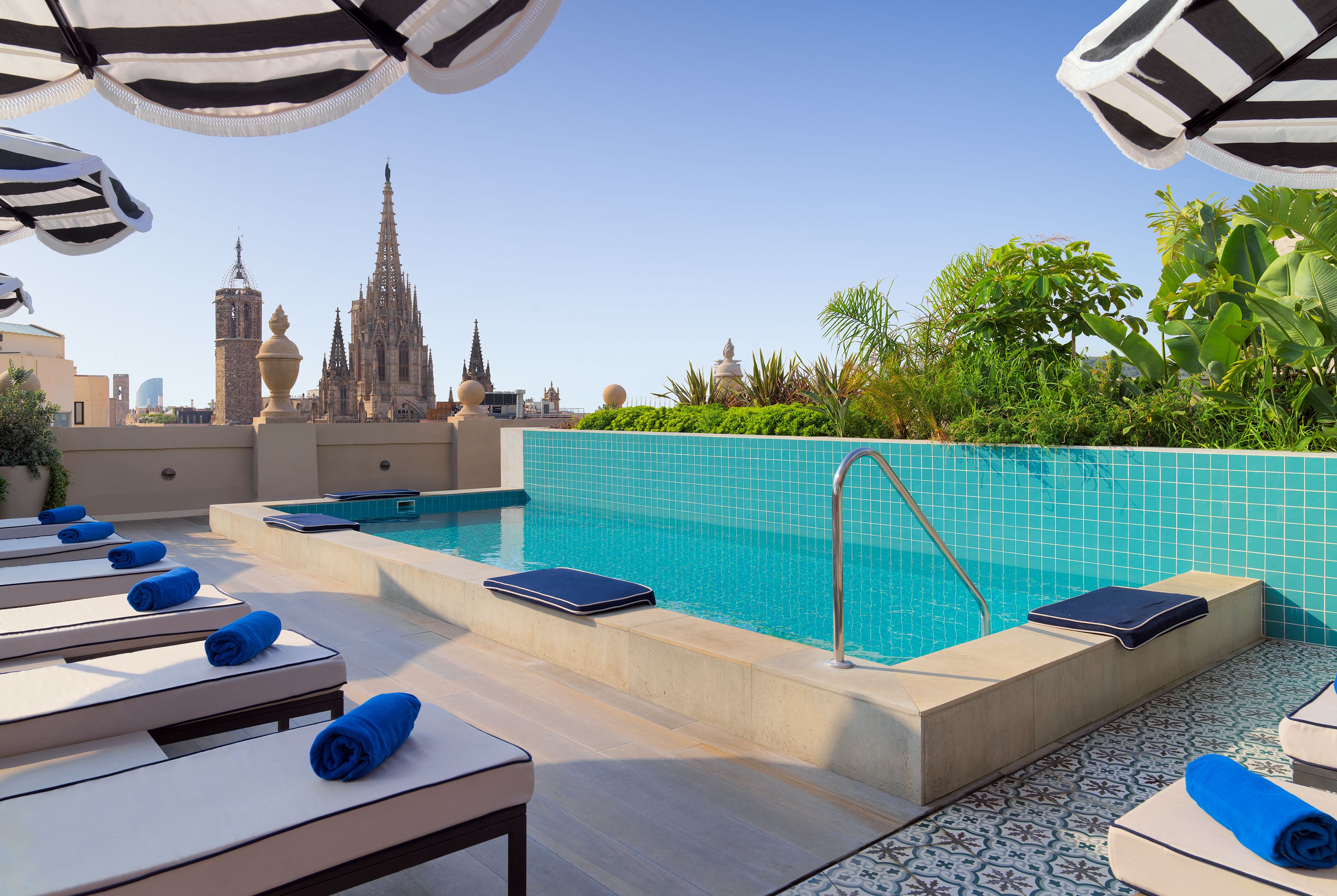 Een buitenzwembad, ligstoelen bij het zwembad