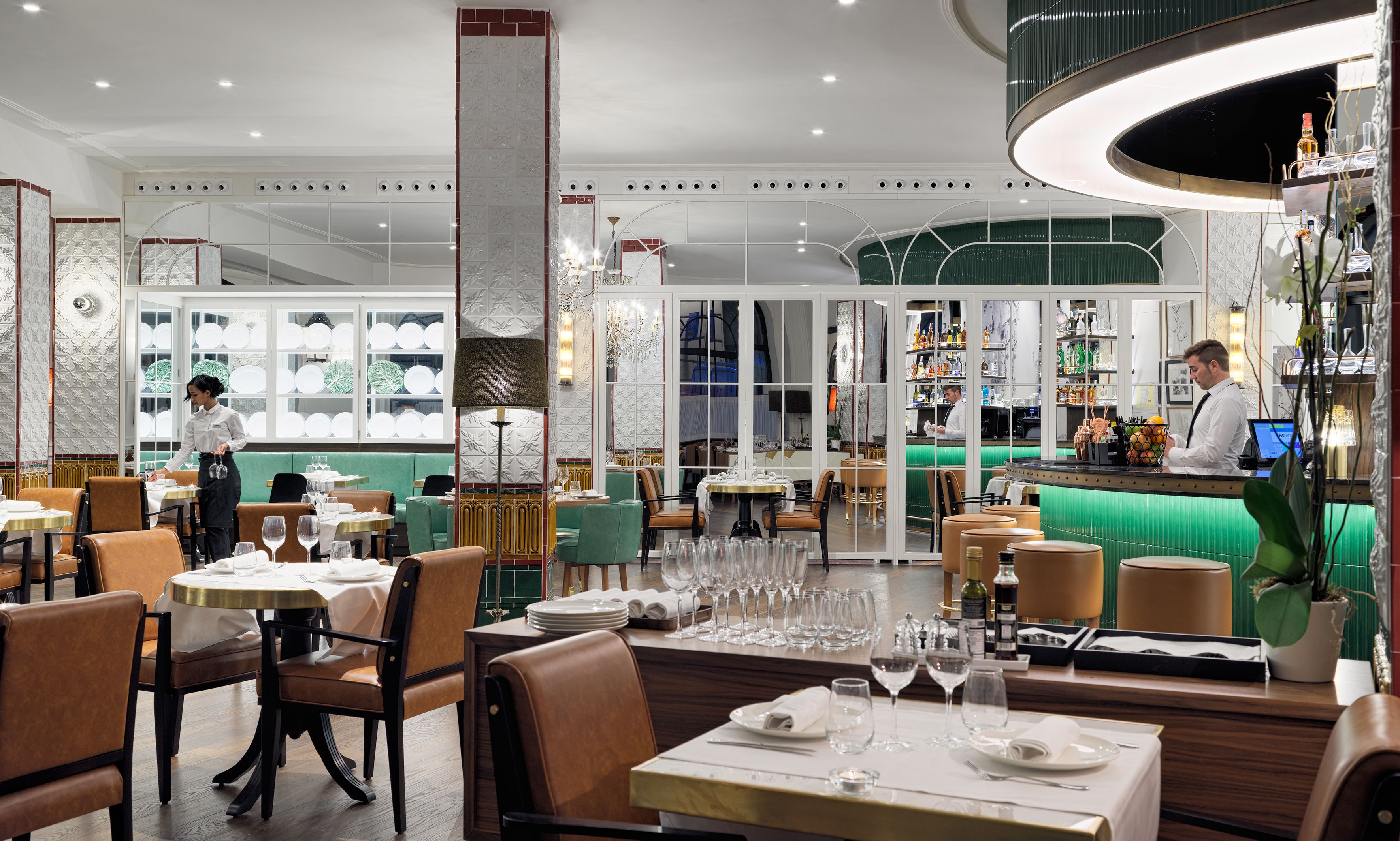 Un restaurant doté d’un bar, de plusieurs tables et d’un barman.