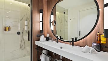 Een moderne badkamer met een grote spiegel, een wit aanrecht en een douche.