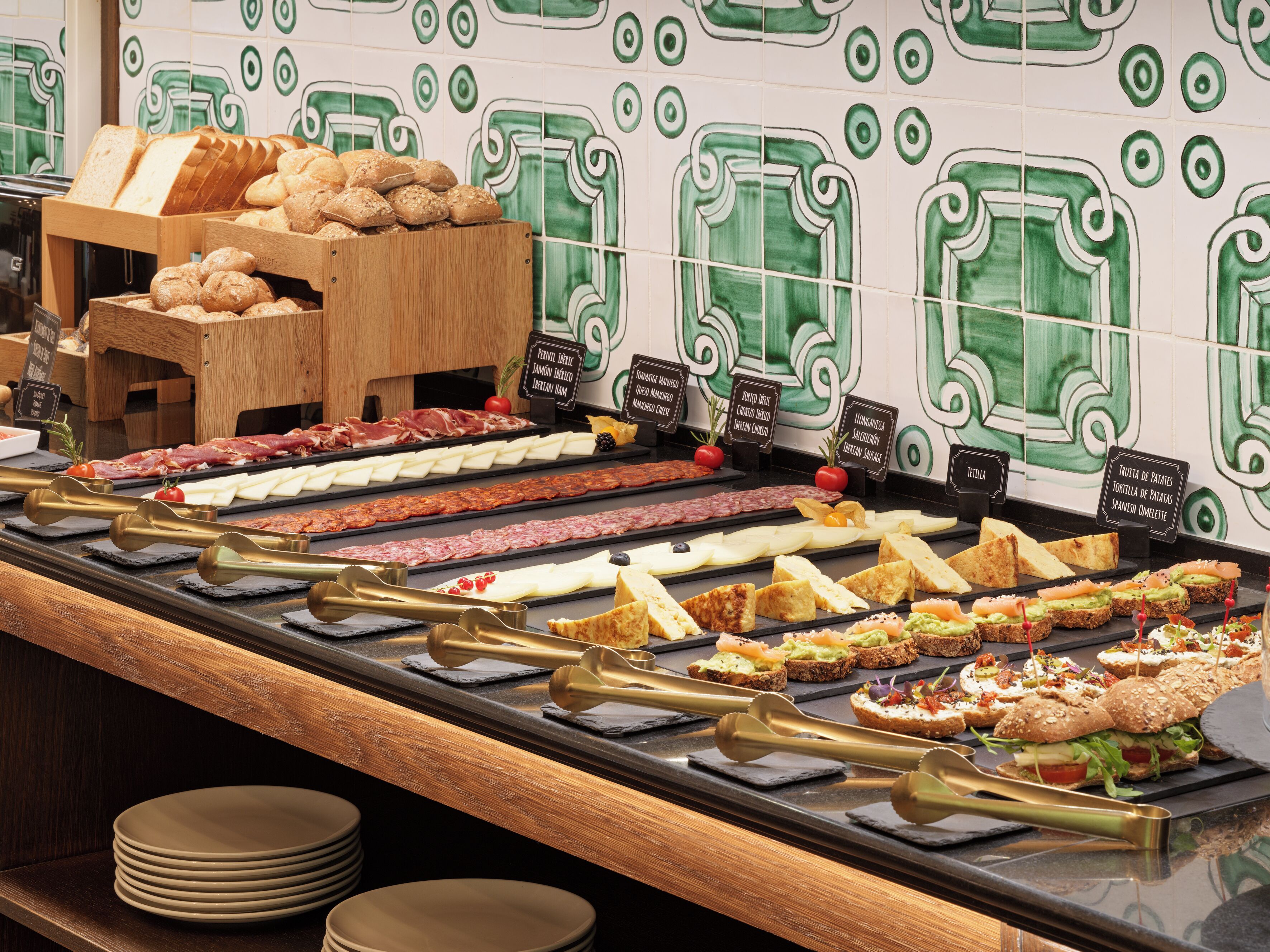 A buffet with various food options including bread, meats, cheeses, and salads.