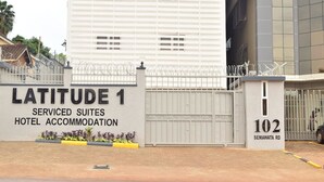 Alojamiento del hotel Latitude 1 Serviced Suites, con entrada protegida y cartel con el número del edificio.
