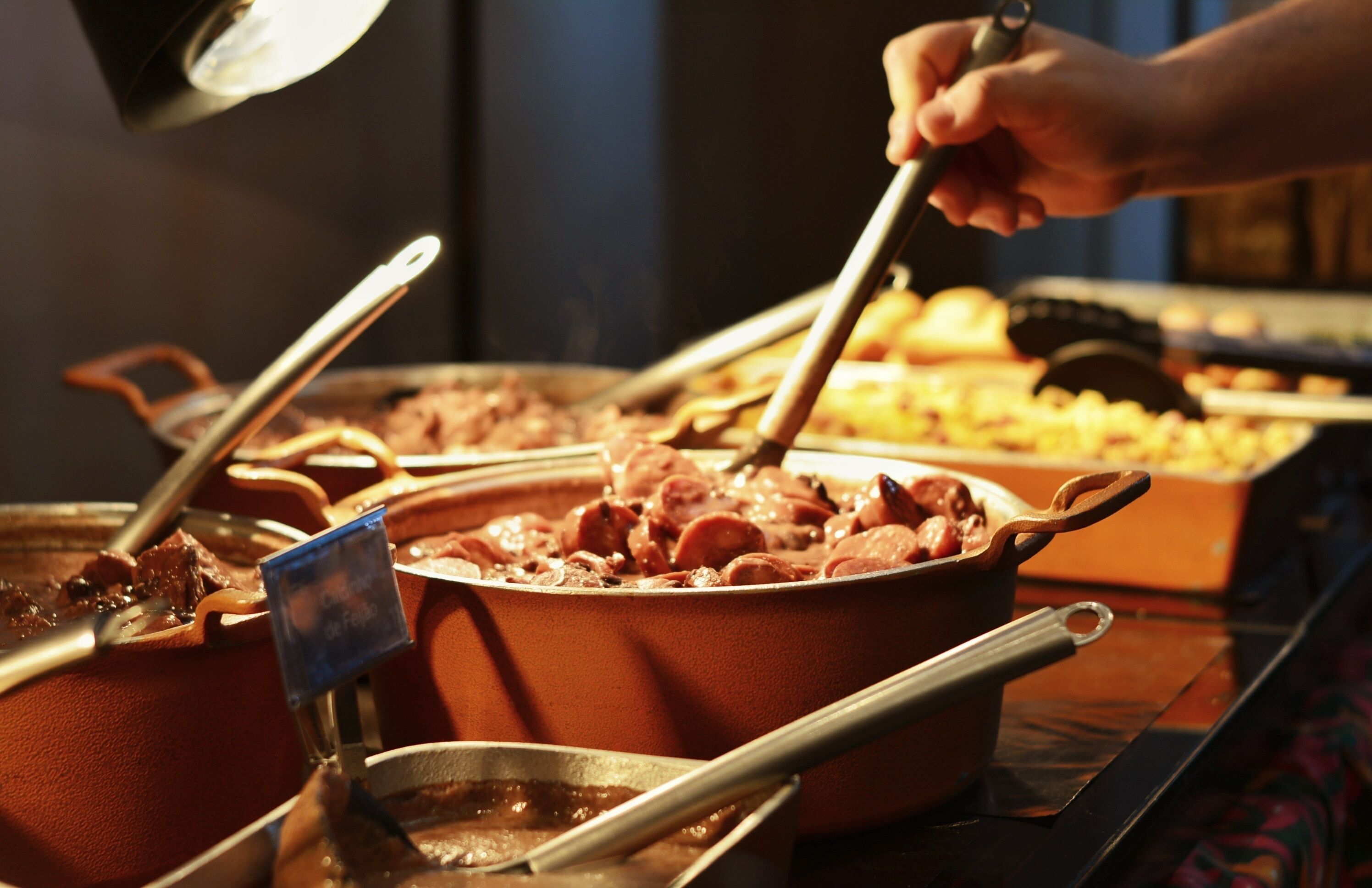 A buffet setup with multiple serving dishes and utensils.