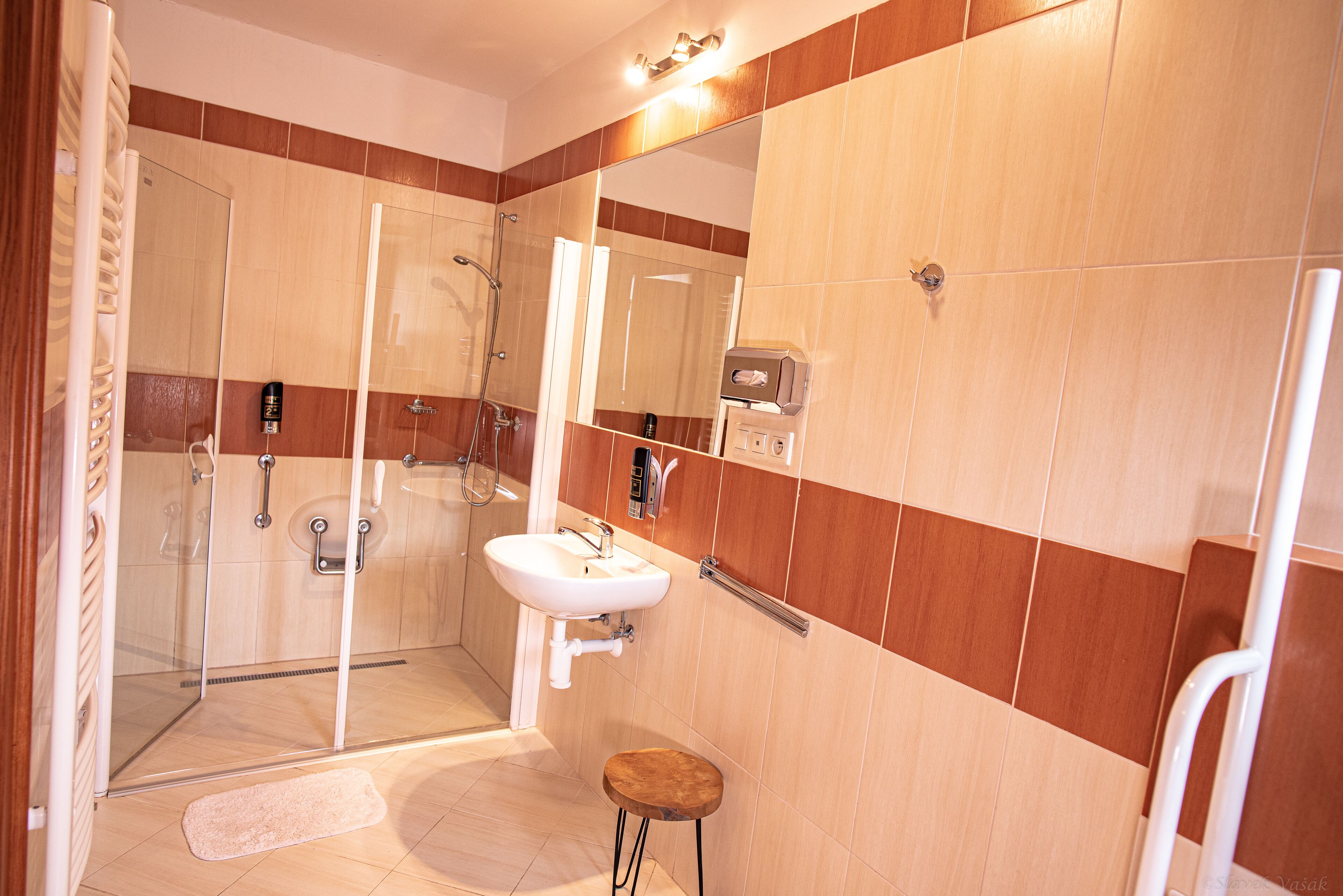 Un baño moderno con cabina de ducha de vidrio, lavamanos y espejo.