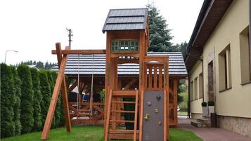 Children can play on the swing set, climb the wall, and explore the tower in this residential play area.