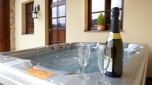 A hot tub with two glasses and a bottle of champagne. - Penzion Staré časy (Horní Becva)