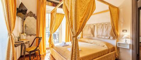 Una habitación con cama con dosel, un escritorio con silla, una estantería y una ventana con cortinas.