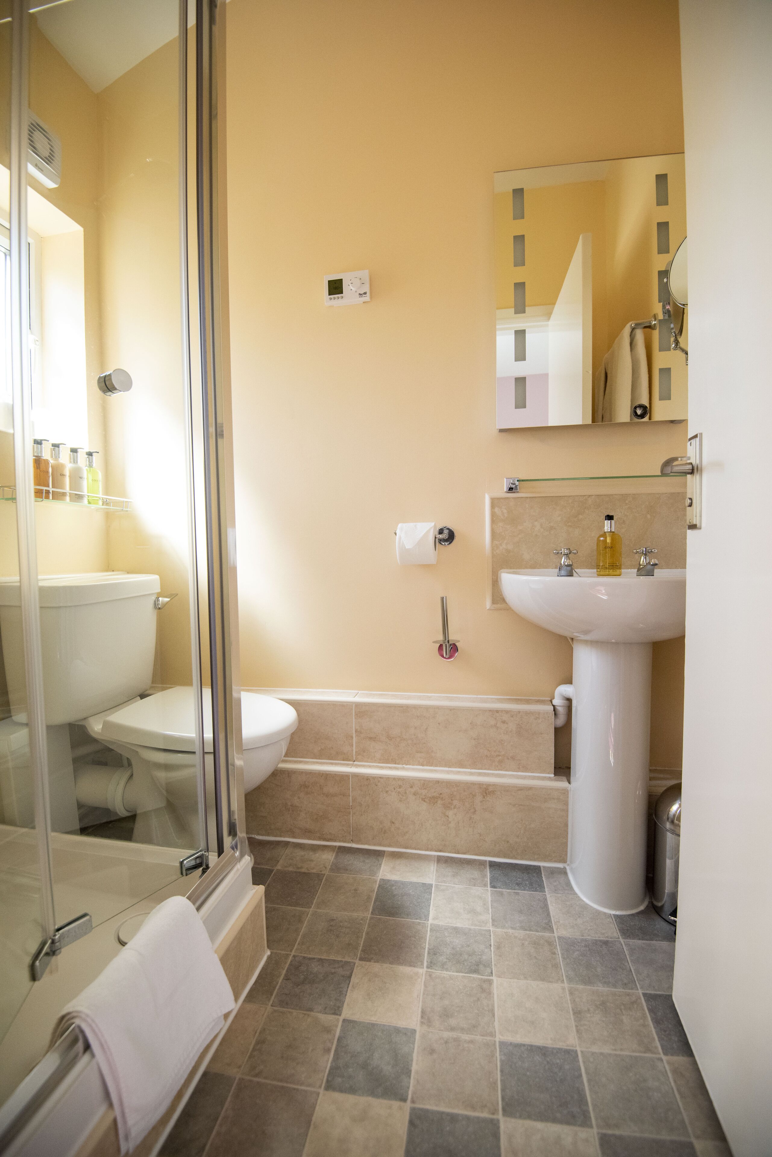 A bathroom with a toilet, sink, and shower.
