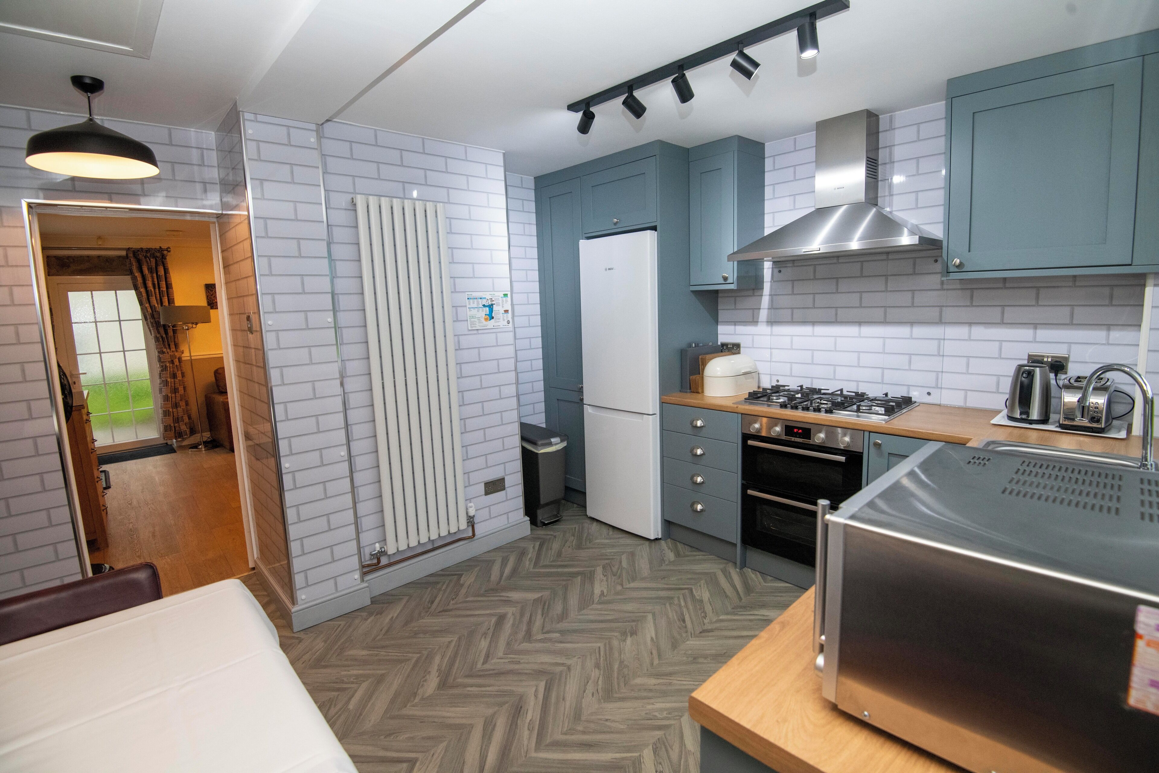 A compact kitchen with a refrigerator, stove, oven, and a microwave.