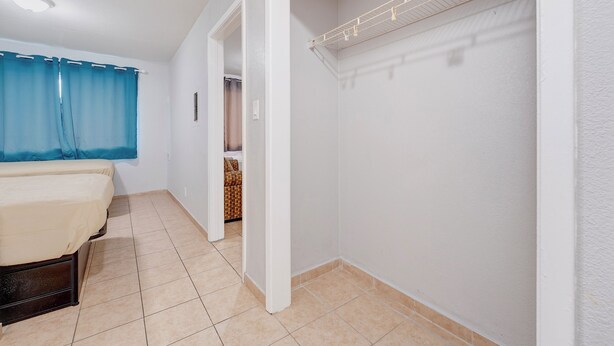 A bedroom with a bed, a wardrobe, and a bathroom visible through an open door.