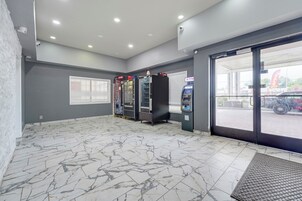 A clean, well-lit indoor area with vending machines, a door leading outside, and a patterned floor.