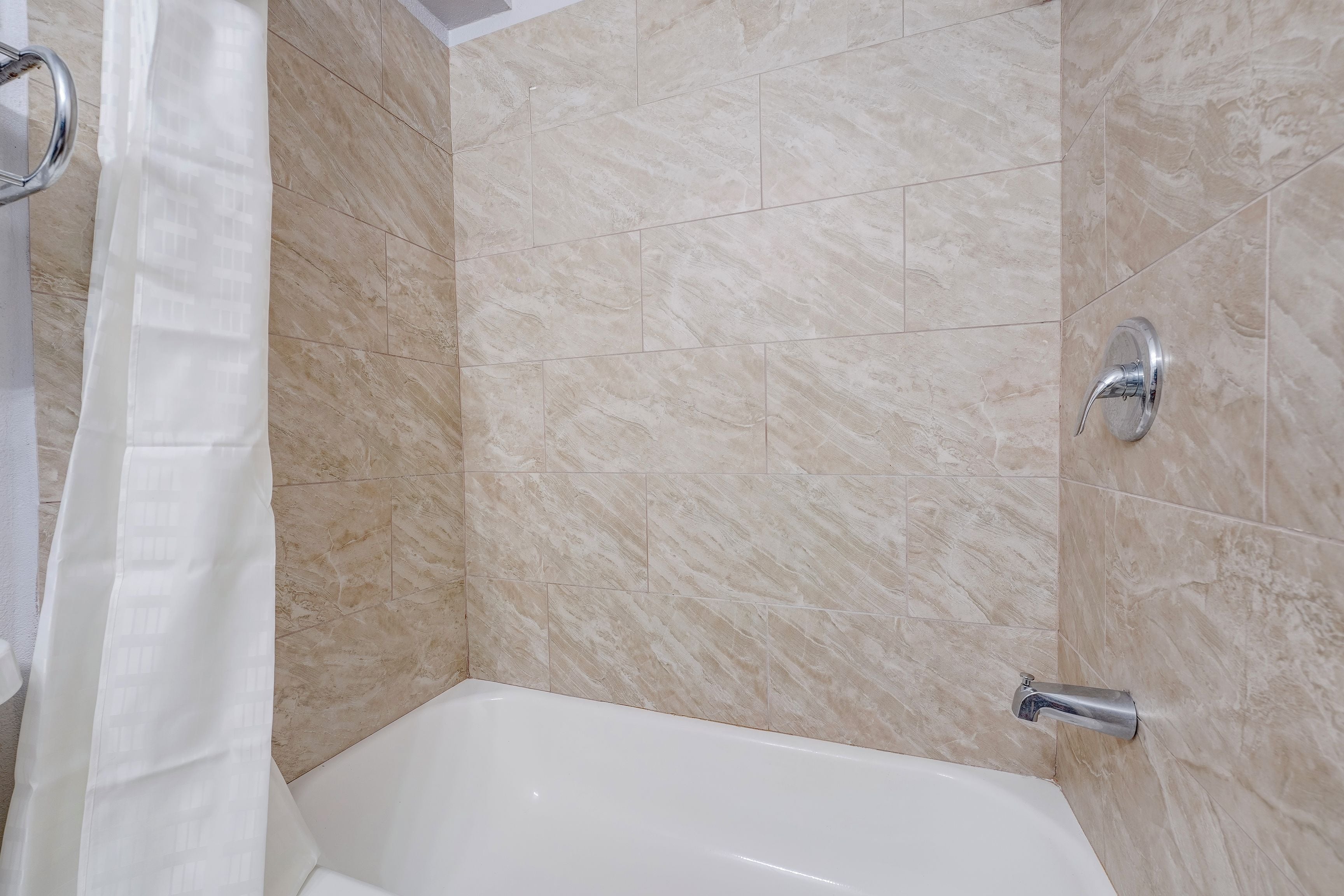 Un baño con bañera, ducha y cortina.