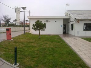 Un bâtiment avec une petite pelouse et un seul arbre.