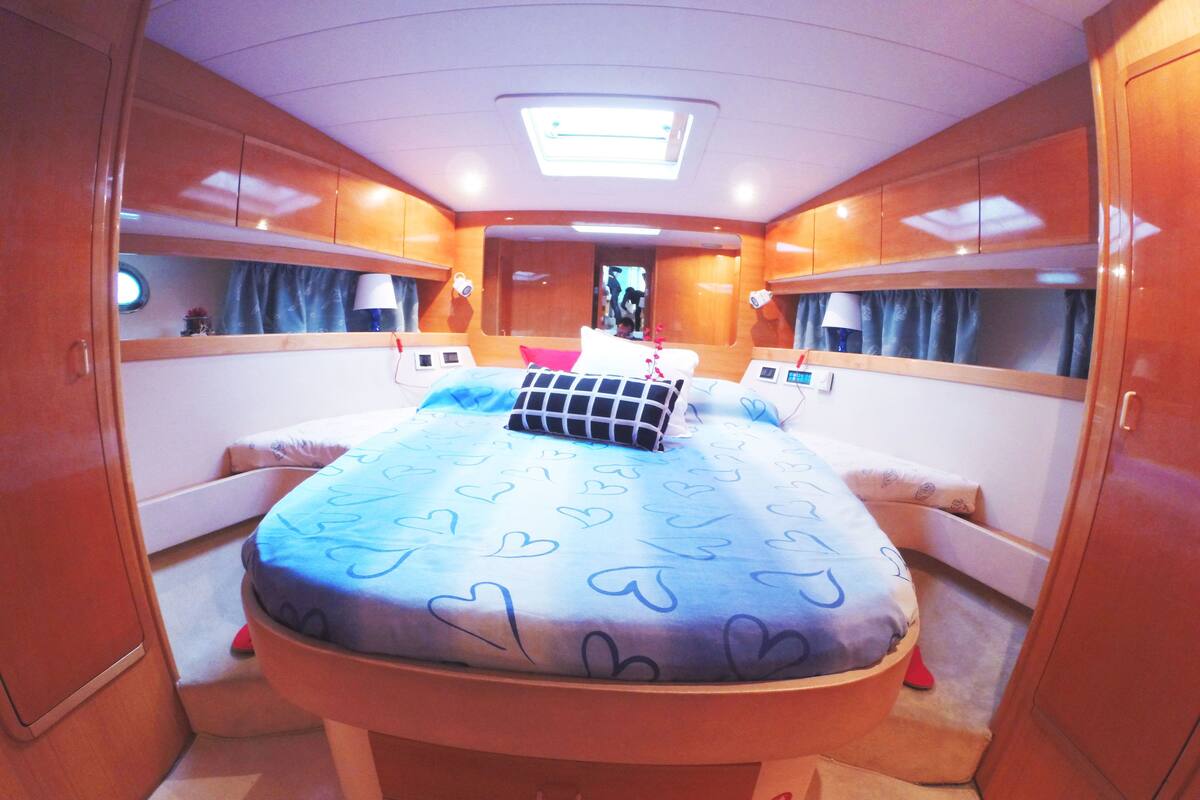 Un dormitorio compacto y bien iluminado con una cama, mesitas de noche y una lámpara de techo.