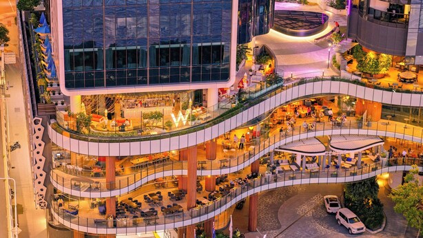 A multi-level shopping mall with various dining areas, a central atrium, and a parking area.