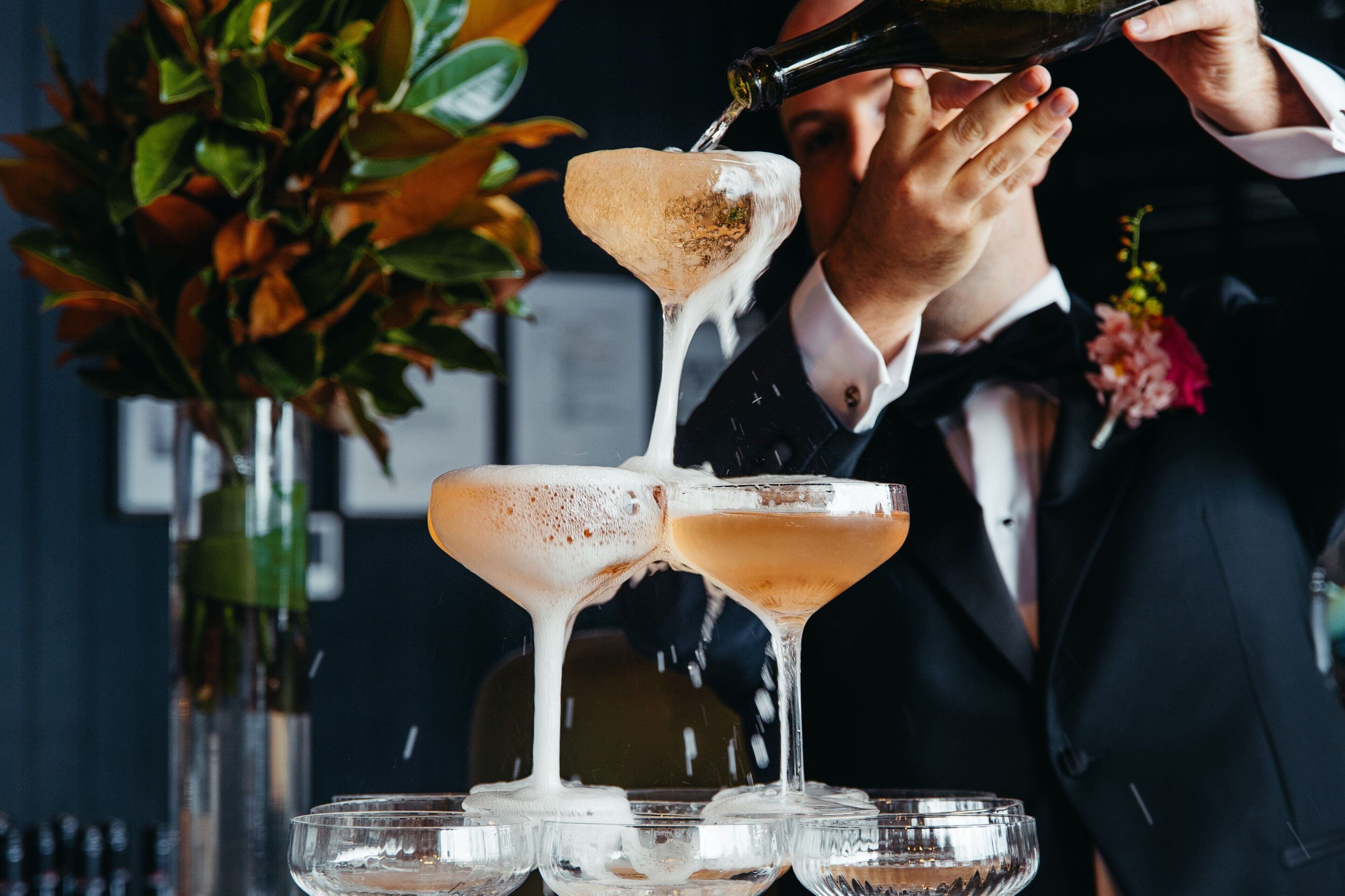 A cocktail being poured into a martini glass.