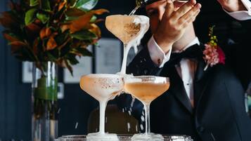 A cocktail being poured into a martini glass.