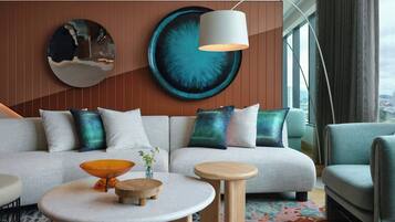 A modern living room with a sofa, two side tables, and a large abstract wall art piece.