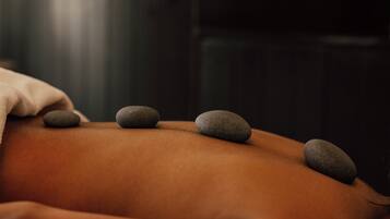 A massage table with stones placed on a person's back.