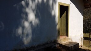 Un bâtiment blanc avec une porte en bois et un petit escalier menant à l’entrée.