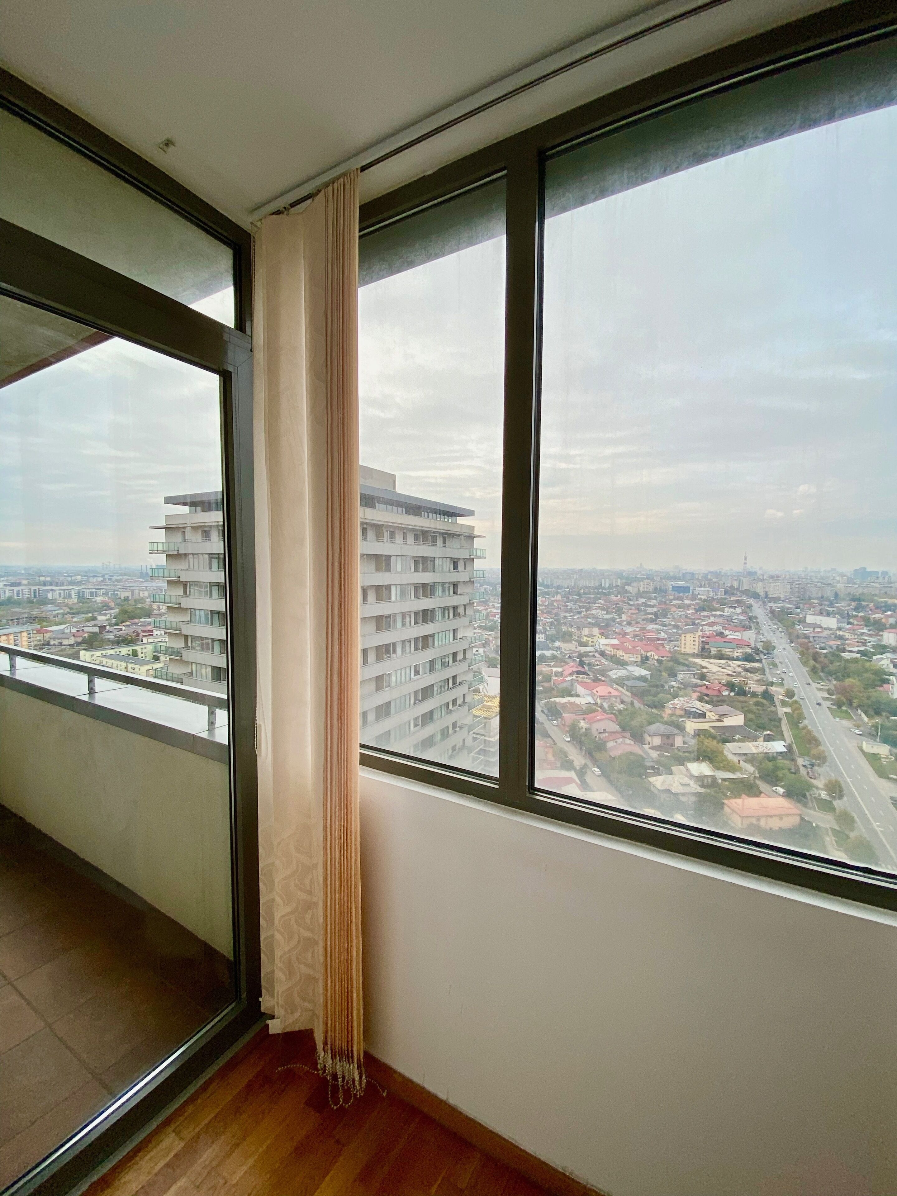 A room with a large window overlooking a cityscape.