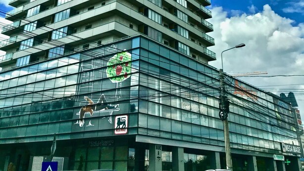 Un edificio alto y moderno con varios pisos y ventanas grandes.