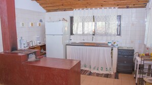 A kitchen with a refrigerator, stove, and various appliances. - Apto 1 ferias na Fazenda Usina And. Sup. (Bocaina de Minas)