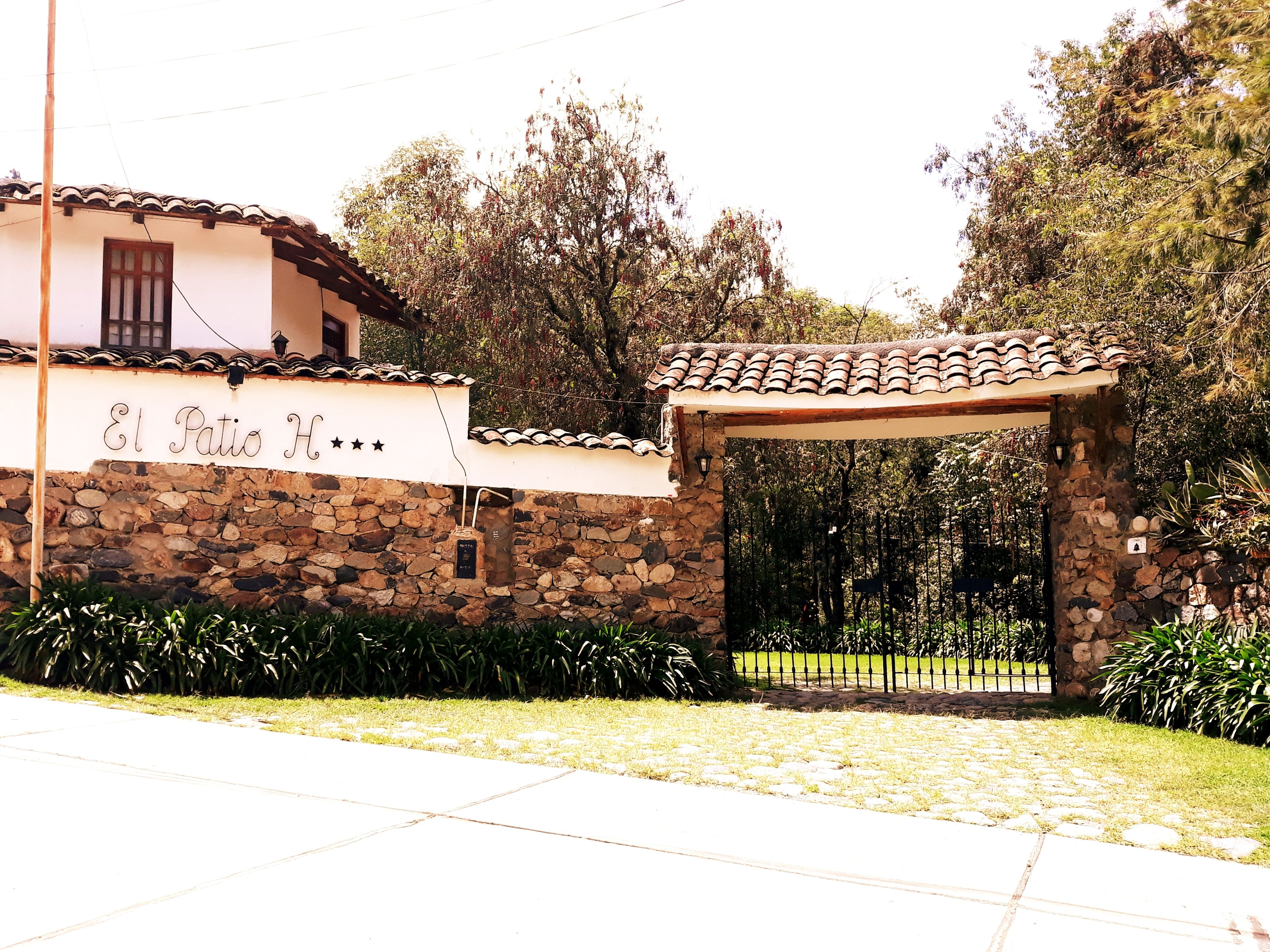 Un bâtiment en pierre avec un toit en tuiles et une enseigne indiquant « El Patio H ».