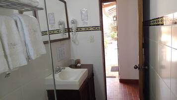 A bathroom with a sink, mirror, and towel rack.