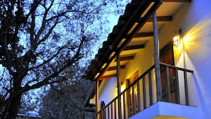 A two-story house with a stone pathway leading to the entrance, surrounded by greenery. - Hotel El Patio de Monterrey (Independencia)